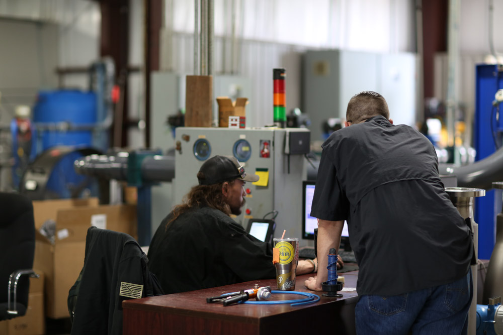 MFT technicians discussing fast flow meter calibration turnaround service